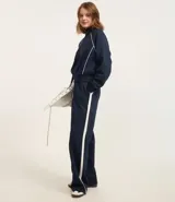 Pantalón de jogging azul marino con raya lateral blanca, corte recto y cintura con lazo.
