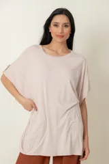 Remera larga de algodón, color beige, con corte oversize y detalle de botón en la manga.