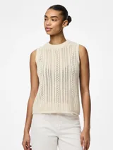 Top tejido color crema, con cuello redondo y sin mangas.