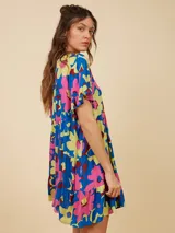 Vestido corto de algodón con estampado de flores en colores vibrantes, con corte suelto y mangas cortas.