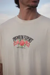 Camiseta color crema de manga corta y cuello redondo, con estampado frontal de rosas y texto "Premium Export".