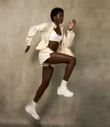 Campera deportiva femenina, modelo rompevientos, confeccionada en poliamida, con cuello alto y puños ajustados. Sin estampa, tiene cierre delantero con cremallera y recortes con hilo reflectante.