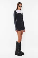 Top deportivo negro de tricot con recortes pisados con bordador, media polera, manga larga con mitones y estampa en lateral del frente y espalda.