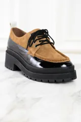 Mocasín abotinado con capellada combinada en cuero color marrón y charol negro.