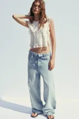 Pantalón de jean celeste de tiro alto con cintura doblada, cinco bolsillos, efecto lavado y roturas.