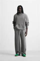 Pantalón jogger negro de corte ancho, confeccionado en tejido de algodón con interior de rizo. Cuenta con cintura elástica ajustable con cordón interior, bolsillos laterales y bolsillo trasero de parche.