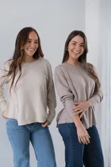Sweater color beige de tejido de punto, corte recto y cuello redondo. Presenta detalle de botones decorativos en el hombro y lateral.