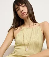 Collar largo con cadena de eslabones dorados y colgante de piedra natural rosa.