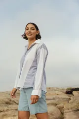 Camisa de lino a rayas verticales azules y blancas, de corte holgado y manga larga.