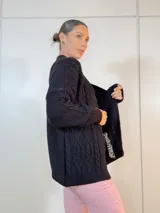 Saco negro de tejido acrílico con diseño abierto y corte largo.