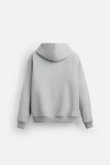 Sudadera con capucha gris confeccionada en tejido de algodón con interior rizo. Tiene manga larga, bolsillo frontal tipo canguro y acabados en rib.