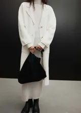 Vestido largo de punto de canalé color crudo, con cuello alto y mangas largas.