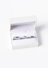 Set de alianzas de acero quirúrgico plateado, con un cintillo de strass y estuche de presentación.