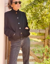 Cardigan negro de lana con cuello alto, cierre frontal con botones grandes, mangas largas y bolsillos delanteros.