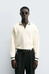 Polo color crema de corte relaxed fit, con cuello solapa con abertura frontal y manga larga. Presenta bordado combinado a contraste en cuello y acabados en rib.