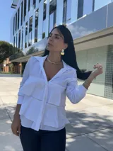 Camisa azul marino de manga larga con cuello camisero y detalle de volados superpuestos en el frente.