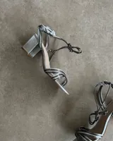 Sandalias plateadas con tiras finas cruzadas y taco de 7 cm.