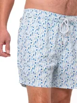 Short de baño celeste con estampado de ballenas en azul y gris. Tiene cintura elástica con cordón ajustable y bolsillos laterales.