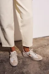 Jean de mujer color crema o blanco roto, de corte baggy y tiro medio. Confeccionado en algodón con un pequeño porcentaje de elastano.