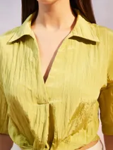 Camisa color verde lima con textura arrugada, corte holgado, mangas cortas y lazo para atar en la parte delantera.