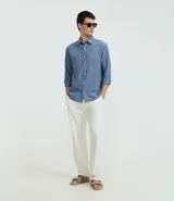 Camisa celeste de lino con cuello camisero, abotonadura frontal y mangas largas.