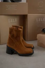 Bota de cuero color marrón con caña media y punta cuadrada.