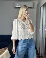 Camisa color crema con detalles de encaje y mangas largas abullonadas de gasa.