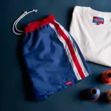 Short de baño azul con cintura elástica roja y rayas verticales blancas y rojas.