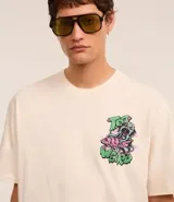 Remera color crema de corte relaxed, con cuello redondo y mangas cortas. Presenta un estampado de un pulpo y letras con la frase "Too weird for earth".