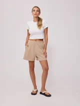 Short color beige de tiro alto con cintura elástica y bordado en el frente.