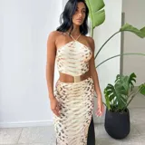 Vestido midi con estampado de piel de serpiente en tonos beige y marrón. Diseño con top halter y falda tubo con abertura lateral.