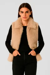 Chaleco de piel sintética color beige, sin mangas y con cuello solapa.