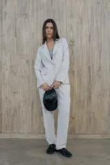 Blazer verde con rayas verticales blancas, solapas clásicas y corte entallado.
