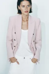 Blazer color rosa pálido de corte entallado y doble botonadura dorada.