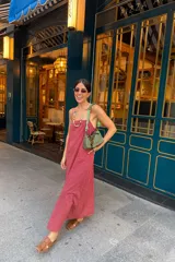 Vestido largo a rayas verticales rojas y negras, con breteles finos y corte recto.