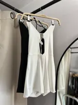 Catsuit corto con escote halter y abertura en el abdomen, con tiras finas para atar en la nuca y en la espalda.