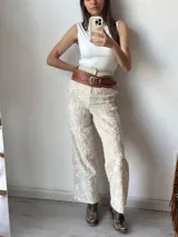 Pantalón de vestir color crudo con bordado floral blanco.