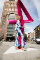 Pantalón de vestir con leve evasé y tajo en laterales, con estampado floral en tonos celeste, blanco y violeta.