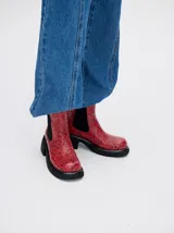 Botas negras de cuero con diseño floral en relieve, corte Chelsea, elásticos laterales, plataforma delantera de 2cm y tacón de 5,5 cm.