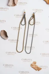 Aros colgantes con diseño irregular y acabado martillado, combinando dorado y plateado. Fabricados en acero quirúrgico hipoalergénico con baño metálico bicolor.