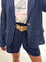 Blazer azul marino con rayas verticales blancas, confeccionado en lino italiano. Tiene botones de coco, solapas clásicas y bolsillos delanteros.