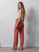 Pantalón verde oliva de rayón con cintura elastizada tipo smock y bordados florales en los bajos.