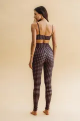 Top corto de tirantes finos, color vino/marrón con estampado geométrico en tonos beige. Presenta escote redondo y es de tejido suave y elástico con ligero brillo satinado.