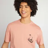 Remera rosa de punto con cuello redondo y estampado de mano sobre un celular.