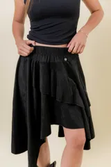 Pollera corta asimétrica de gamuza color marrón, con volados superpuestos y cintura elastizada. Incluye short interno.