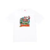Remera blanca de manga corta con estampado gráfico de Papá Noel y duendes navideños, con el logo de Supreme en la parte inferior.