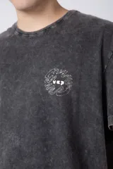 Remera gris con efecto gastado, corte semi-oversize y estampado pequeño en el pecho con un diseño de un girasol.