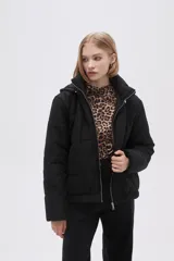 Campera puffer color rosa pálido con capucha, cierre frontal con cremallera y bolsillos laterales.