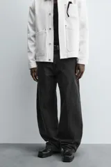 Pantalón de jean celeste con efecto lavado, corte holgado desde la cadera que se estrecha ligeramente en el bajo, tiro medio, cinco bolsillos y cierre frontal con cremallera y botón.