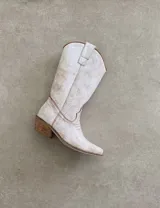 Botas de cuero negro con bordado decorativo en el caño y empeine, taco bajo y punta fina. Diseño de estilo cowboy.